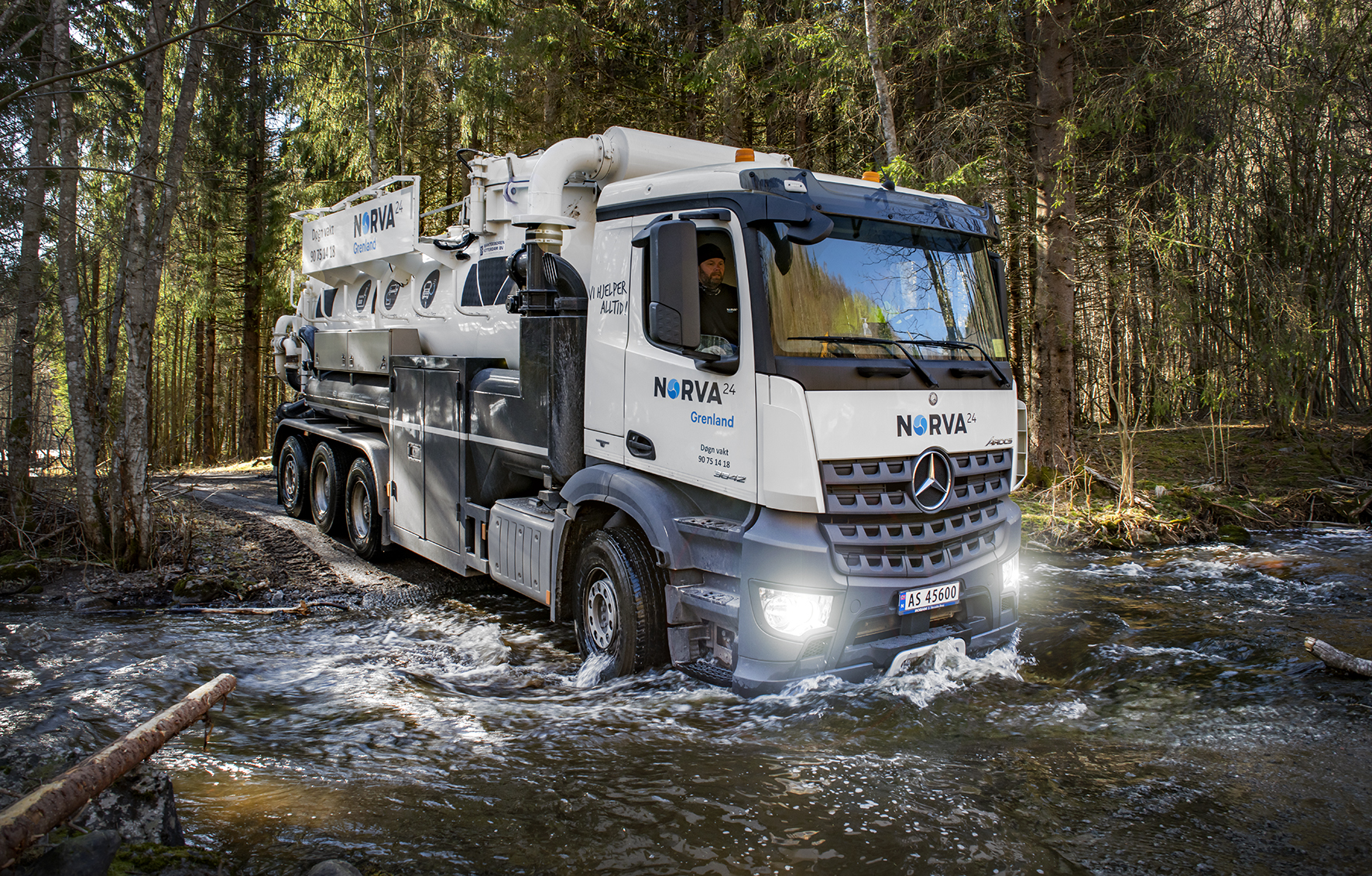 Saugwagen überquert einen Bach, um Reinigungsarbeiten in einem Wald durchzuführen