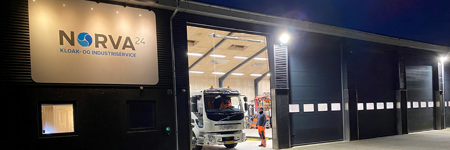 Norva24 bygning med skilt og åbent værksted, hvor en lastbil holdes klar til service