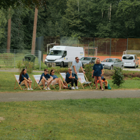 Grupp personer som sitter i solstolar utomhus under en paus vid ett evenemang.