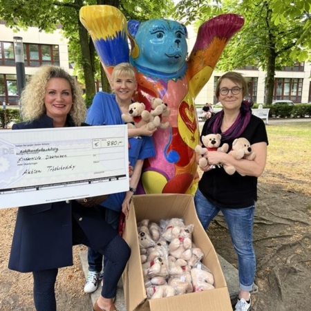 Tre kvinnor med donationscheck och 
