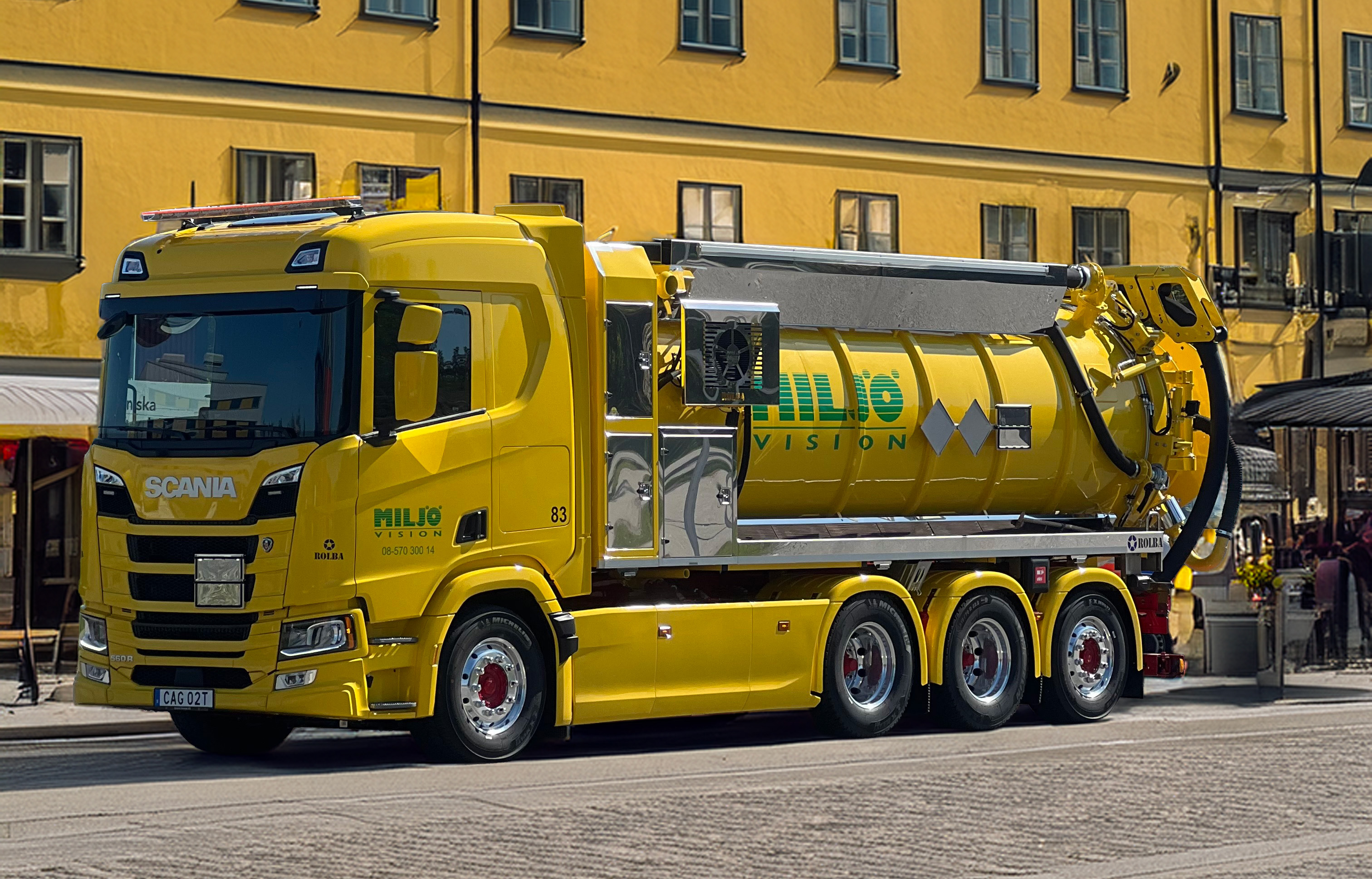 Gul Scania sopsugtruck från Miljö Vision på kullerstensgata