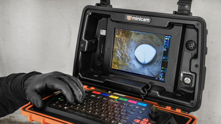 Camera system inspecting a pipe with a screen showing the view inside