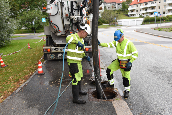 Cleaning a sand trap in an urban area using specialized equipment.