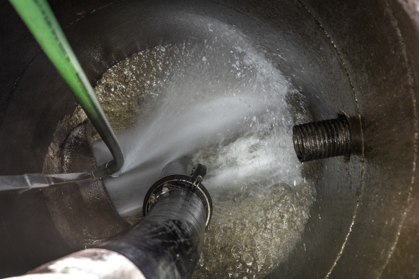 High-pressure flushing inside a tank to remove contaminants.