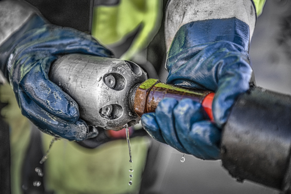 Preparing a high-pressure flushing nozzle for pipe cleaning.