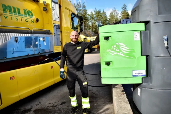 Man refueling yellow truck with HVO biofuel at depot
