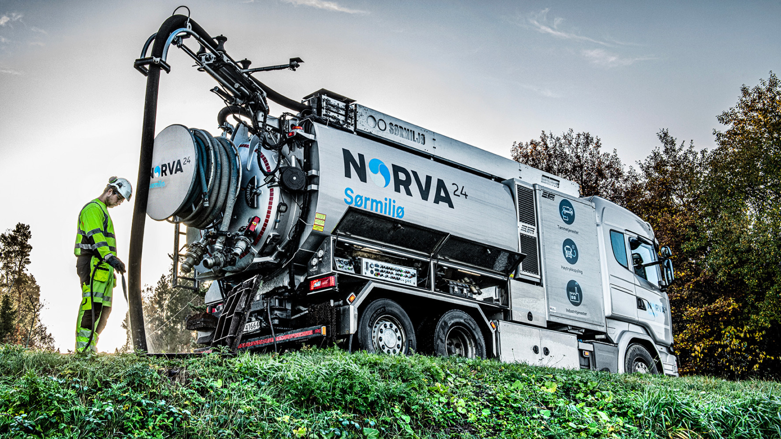 Norva24 Sørmiljø vacuum truck with worker in hi-vis gear operating sewage equipment outdoors