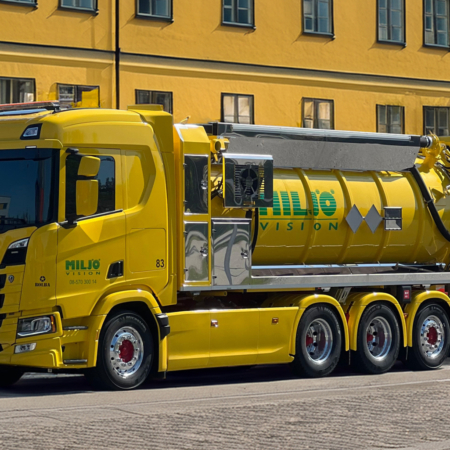 Yellow Scania vacuum truck from Miljö Vision on cobblestone street