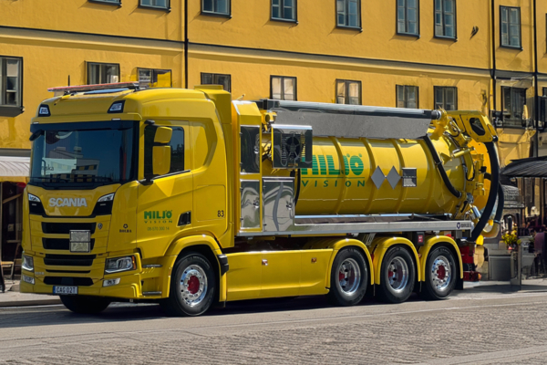 Yellow Scania vacuum truck from Miljö Vision on cobblestone street