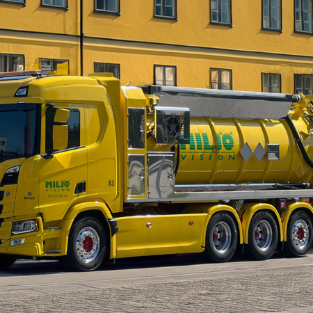 Yellow Scania vacuum truck from Miljö Vision on cobblestone street