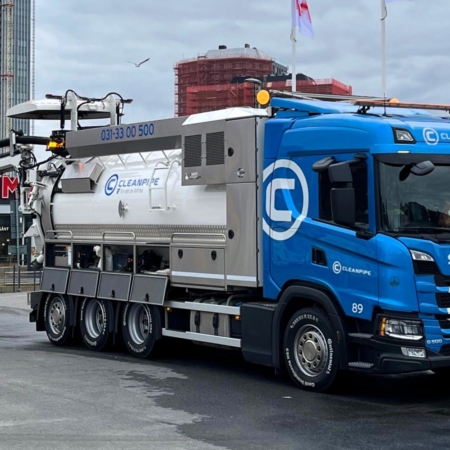 Blue Cleanpipe Scania vacuum truck with worker at Gothenburg construction site