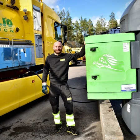 Man refueling yellow truck with HVO biofuel at depot
