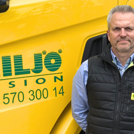 Man standing beside yellow Miljö Vision truck with company branding and phone number