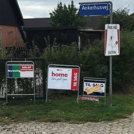 Residential street corner with sale signs, a 